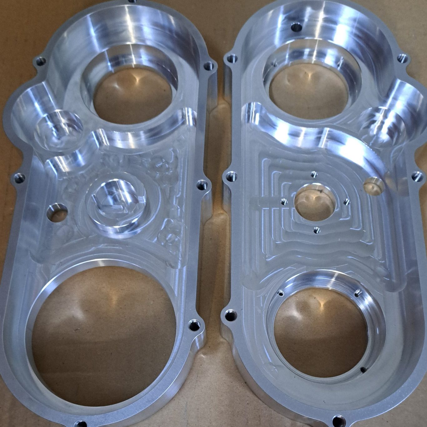 Zwei präzise bearbeitete Metallkomponenten mit kreisförmigen Ausschnitten.